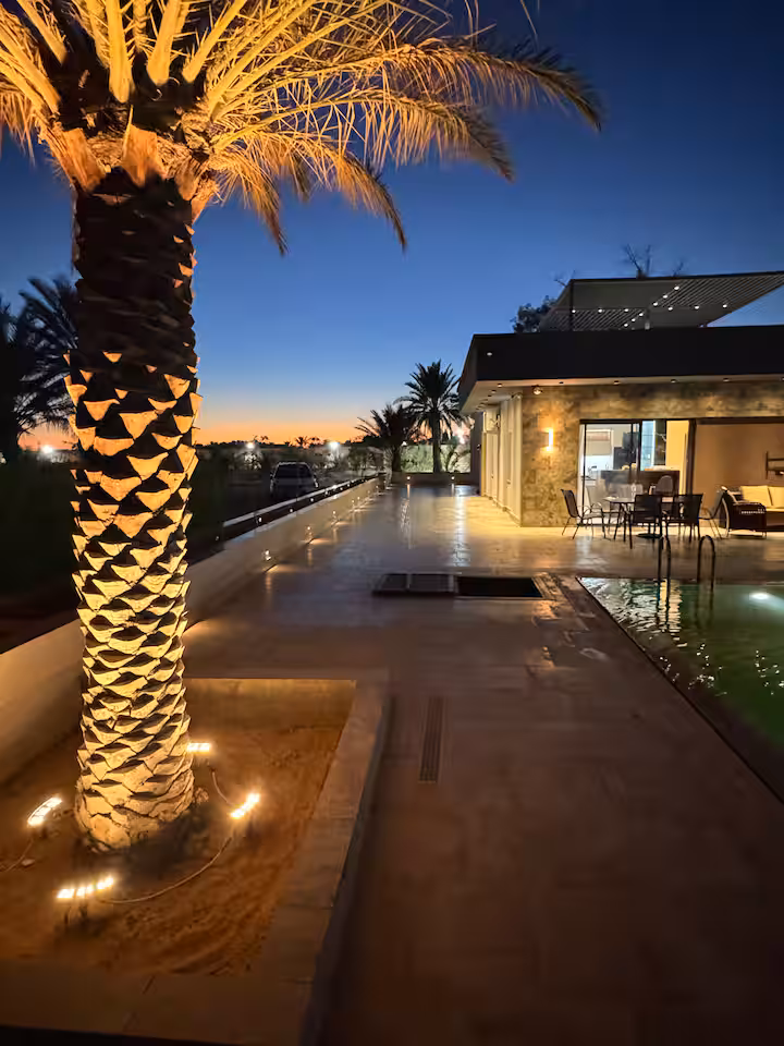 La villa et les palmiers illuminés à la nuit tombée